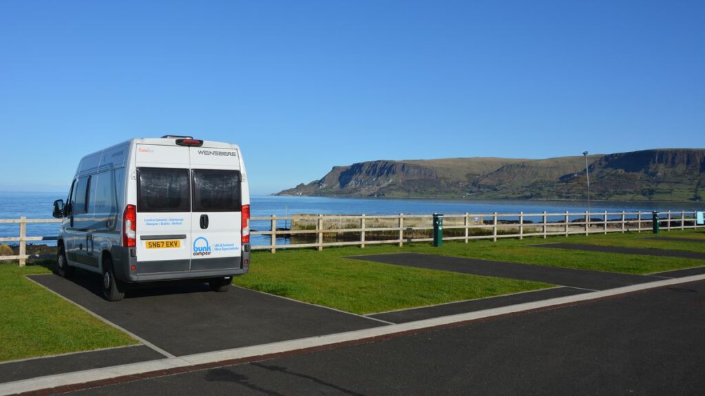 Small motorhome parked on a stopover site by the sea