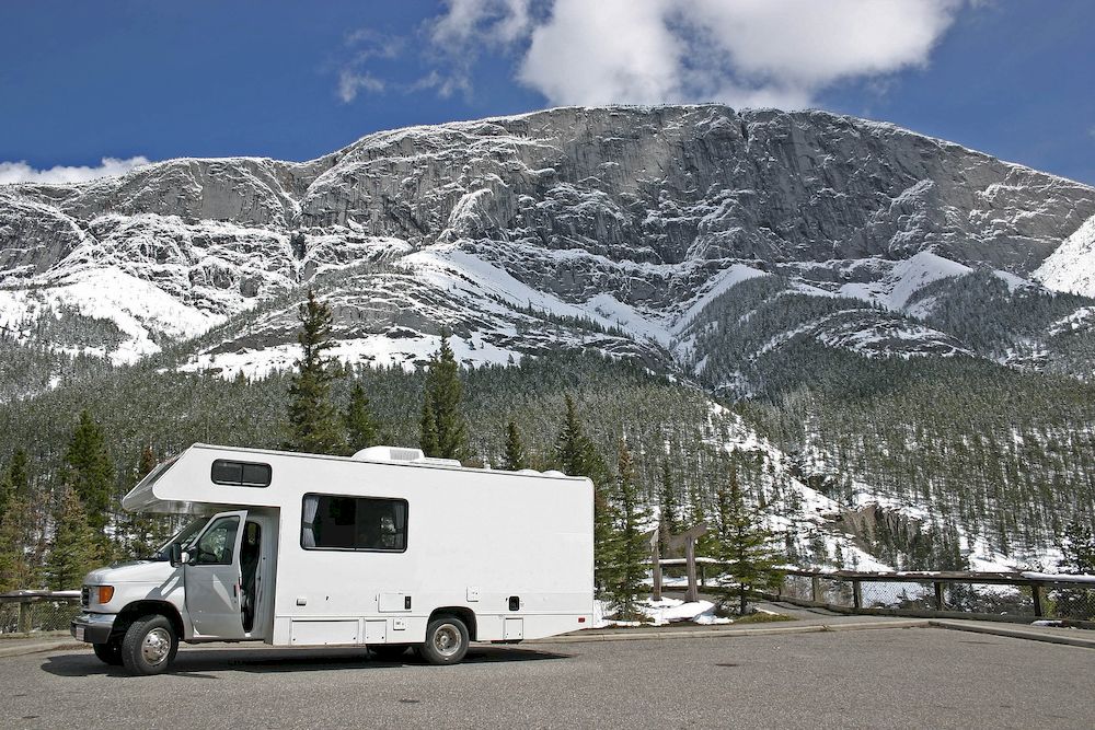 An American motorhome in front of snow covered mountains