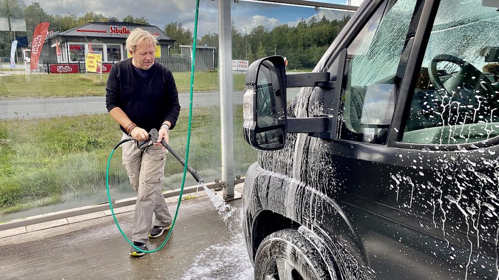 En man tvättar en husbil 