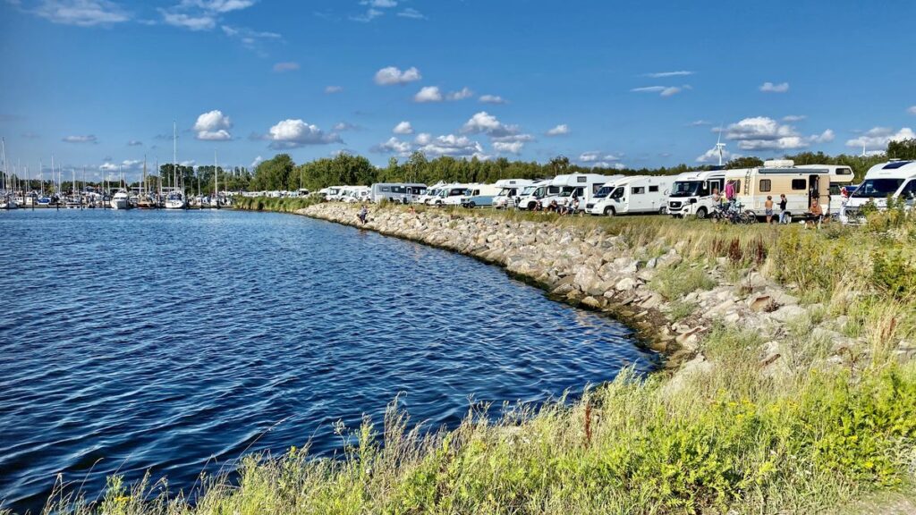 Alt: Husbilar på rad på ställplats i Skåne, vid vattnet