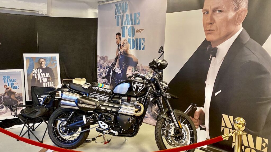 Motorcykel och affischer om “No Time to Die” på museum